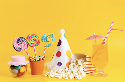 popcorn-und-lutscher-aus-der-vorderansicht-sowie-lustiger-hut-und-cocktail-auf-gelb